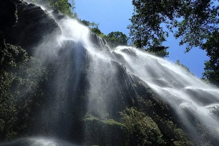 Water cascading down a wide, textured rock waterfall