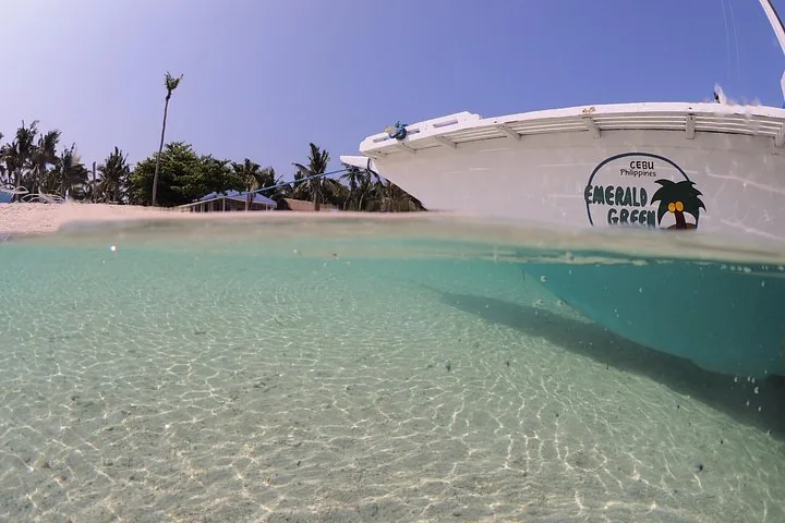 Split-level view of a boat resting in shallow clear water